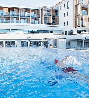 Schwimmer im Außenpool schwimmt eine Bahn